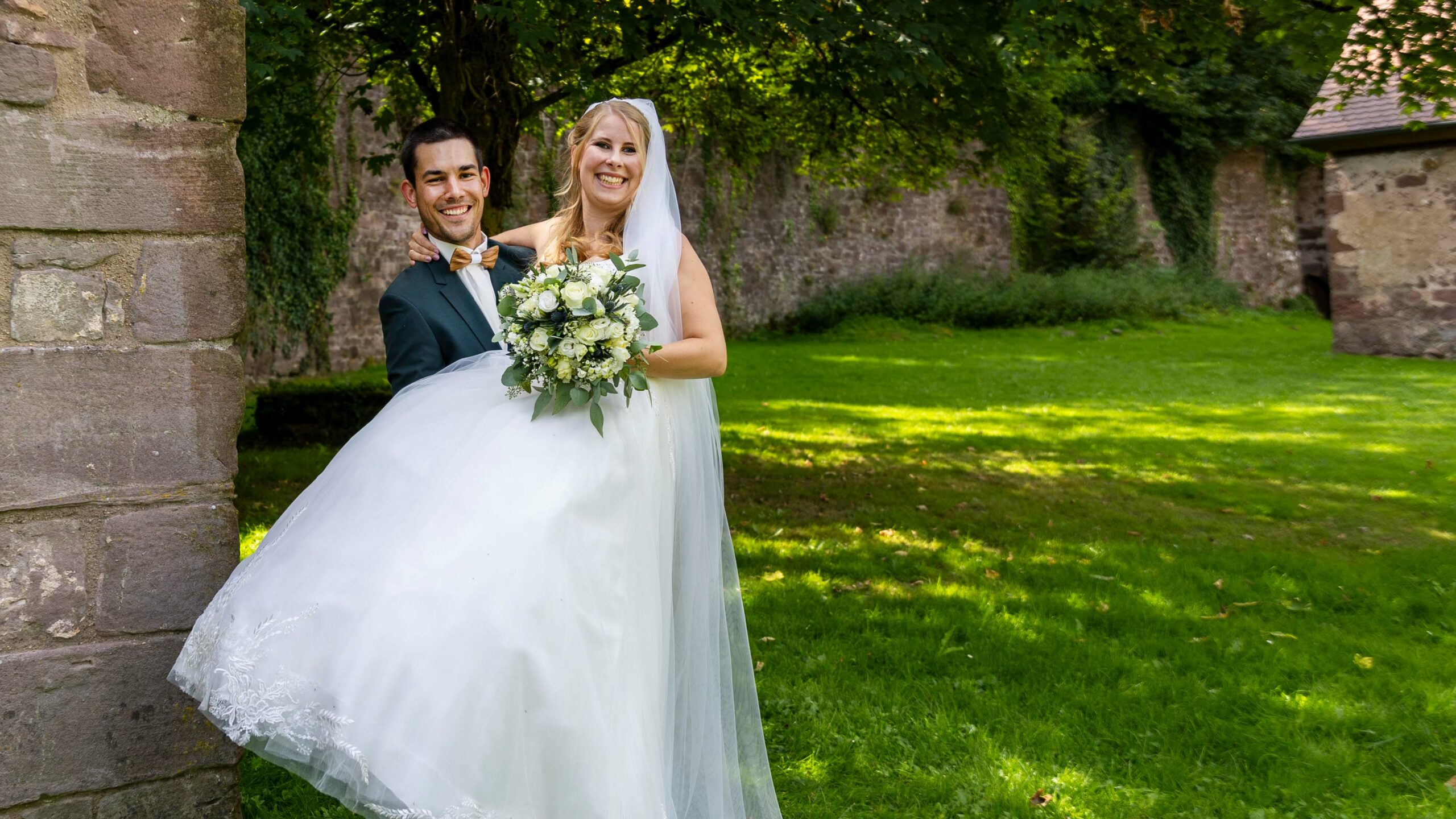 a man carrying a woman in a wedding dress